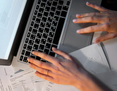 Mains qui pianotent sur clavier d'ordinateur